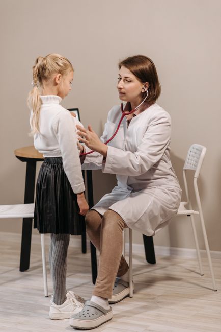 Asian doctor examining child patient with stethoscope